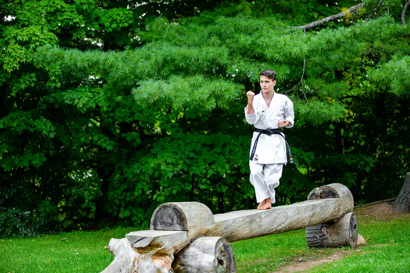 KTK Martial Arts student performing a kata while balancing on a log. Sport photography by Jeffrey Meyer